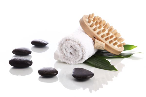 Towel and brush with zen stones over white background